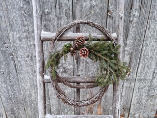 christmas decoration on old weather ladder resting on a old house wall