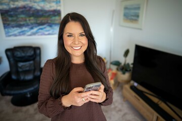 Fototapeta premium Girl video calling her friends on a zoom call. Woman on holiday skyping her family outside in a beautiful place