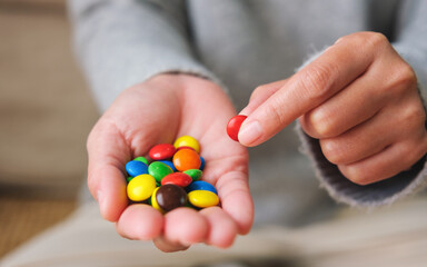 Closeup image of hands holding and picking colorful chocolate candy