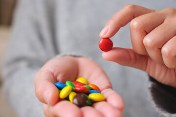 Closeup image of hands holding and picking colorful chocolate candy
