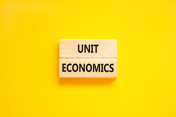 Unit economics symbol. Concept words Unit economics on wooden blocks. Beautiful yellow table yellow background. Business and unit economics concept. Copy space.