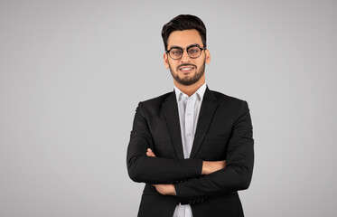 Portrait Of Confident Young Arab Businessman In Eyeglasses Standing With Folded Arms