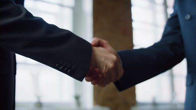 Closeup men shaking hands at office meeting. Handshaking on negotiation concept