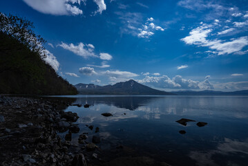 静かな湖面に映る山と青空