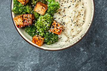 Vegan tofu poke bowl with rice and broccoli on a light background. Clean eating, dieting, vegan food concept. top view