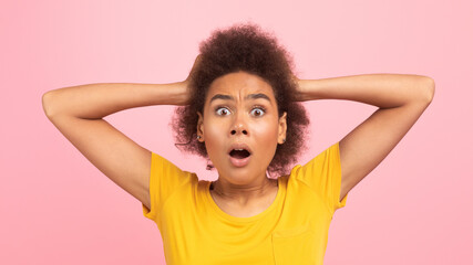 Shocked emotional young black curly woman screaming with open mouth, hold hand with hands