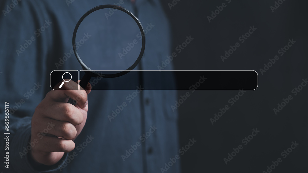 Wall mural hand holding magnifying glass. searching for information. using search console with your website. da