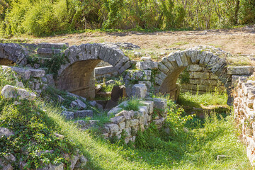 Fototapeta na wymiar Close up of a ruined vaulted bridge in the Roman ruins of Salona, just outside Solin near Split