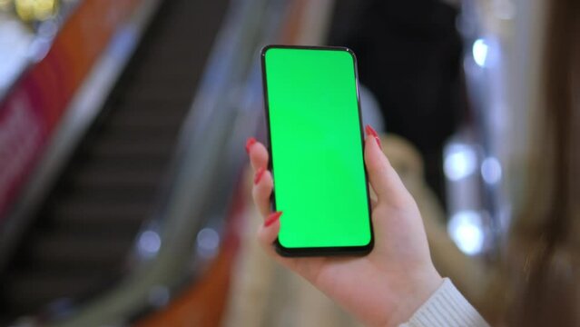 Mall. Use green screen for copy space closeup. Chroma key mock-up on smartphone in hand. hold mobile phone and looking photos or pictures