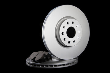 Automotive spare parts from the braking system. Brake pads and discs on a black background, close-up