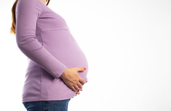 Pregnant girl in a purple sweater on a white background. The concept of weight gain during pregnancy. Overweight. Copy space for text
