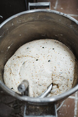Shot of seed bread dough already kneaded in a mixer machine in bakery