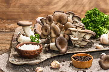 Oyster mushrooms ready for cooking. Fresh parsley, spices, garlic. Trendy hard light, dark shadows