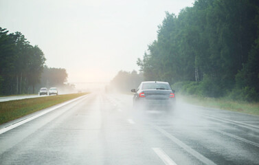 a passenger car is driving on a slippery highway from the rain. Heavy fog and rain on the highway. Bad visibility. Copy space for text