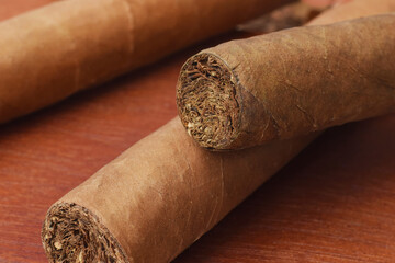 Handmade tobacco cigars on wooden desk macro low key background