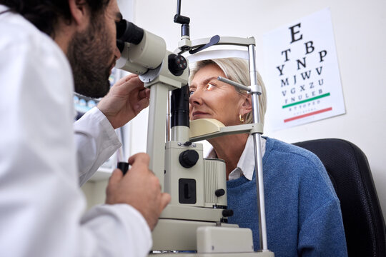 Vision, machine exam and woman with an optometrist for a check, eye consultation and lens test. Healthcare, help and male optician with a senior patient to measure visual eyesight with equipment