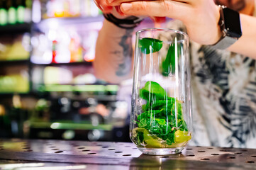 bartender preparing mojito cocktail drink in bar