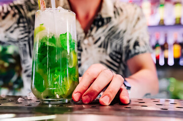 bartender preparing mojito cocktail drink in bar