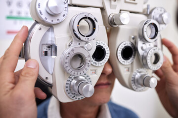 Eye care, exam and vision test machine with patient and doctor at optometry consultation for lens...