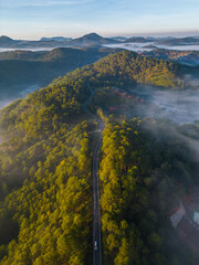Winding road from high mountain pass, in spring time. Aerial view by drone 