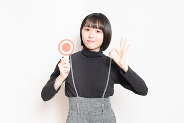 OKのプレートを見せている若い女性