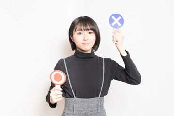 NGのプレートを見せている若い女性