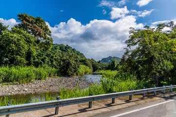 Fototapeta na wymiar A view towards a river in the foothills of the tropical rainforest in Puerto Rico on a bright sunny day