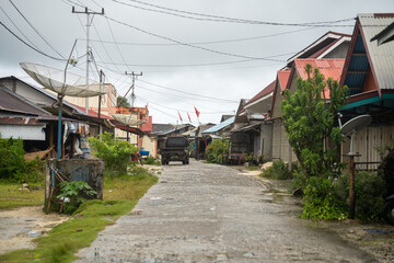 Fototapeta na wymiar Exploring the Traditional Indonesian Town: A Scenic View of a Road with Houses