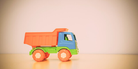 Retro plastic colorful truck toy with orange bodywork.