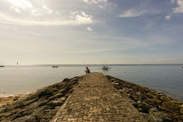 Fototapeta na wymiar Silhouette of a middle-aged man sitting on the beach