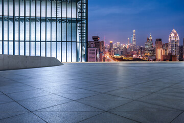 Fototapeta na wymiar Empty square floor and city skyline with modern building at night in Shanghai, China.