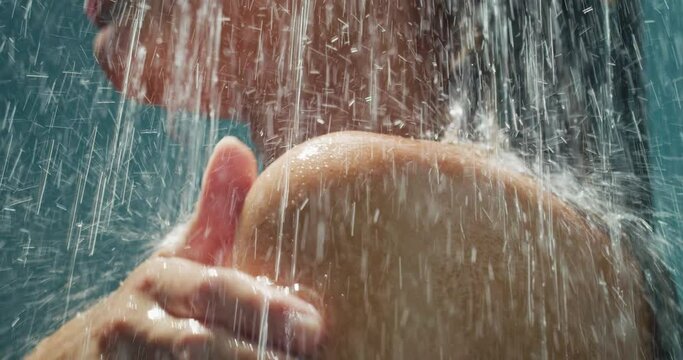 Close up of Young Woman Washing her Shoulder while Relaxing Under Hot Running Water in a Shower at Home. Female Taking Care of her Beauty and Skin. Concept of Wellness and Skincare