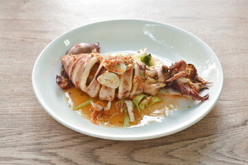 grilled squid dressing spicy and sour lemon sauce isolated on plate