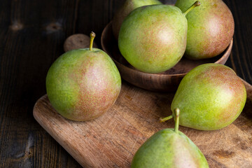 Whole ripe green pears on the board