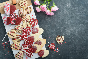 Valentines day cookies. Shortbread cookies inside sweet red heart with chocolate glaze on pink plate on grey background. Mothers day. Womans day. Sweet holidays baking. Valentines day card. Top view.