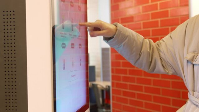 mother and daughter make an order of dishes in the cafe on the self-service terminal. the concept of an electronic menu for a restaurant.