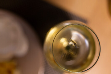 White wine served on a transparent drinking glass on a wooden table background