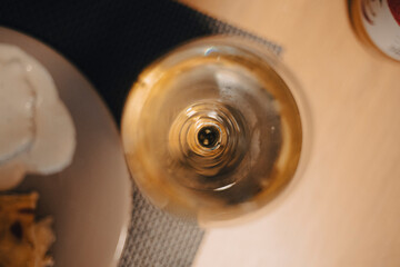 White wine served on a transparent drinking glass on a wooden table background