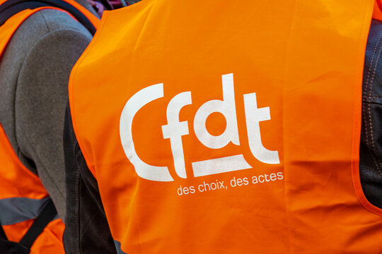 Paris, France - 7 f&eacute;vrier 2023: Logo de l'organisation syndicale fran&ccedil;aise CFDT (Conf&eacute;d&eacute;ration Fran&ccedil;aise D&eacute;mocratique du Travail) sur un gilet orange photographi&eacute; gros plan pendant une manifestation