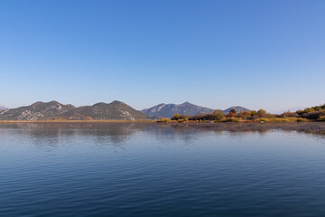 Fototapeta premium Scenic view of Lake Skadar National Park in autumn near Virpazar, Bar, Montenegro, Balkans, Europe. Travel destination in Dinaric Alps, Albanian border. Stunning landscape water reflection in nature