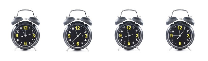 close up of a set of black alarm clocks showing the time; 11, 11.15, 11.30 and 11.45 p.m dan a.m. Isolated on white background - obrazy, fototapety, plakaty