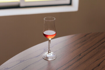 A glass of yellow beverage traditional Portuguese sweet wine - muscatel on a wooden table