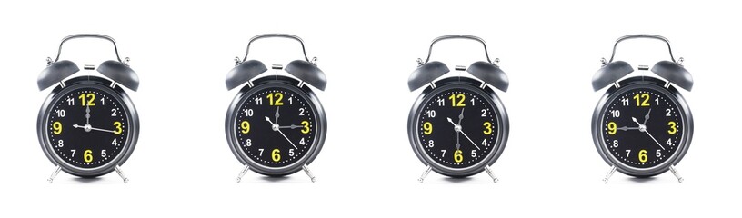 close up of a set of black alarm clocks showing the time; 12, 12.15, 12.30 and 12.45 p.m dan a.m. Isolated on white background - obrazy, fototapety, plakaty