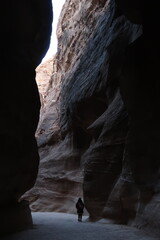 Silhouette of a girl walking in the Siq Canyon, Petra, Jordan