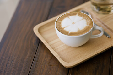 hot coffee in white cup on brown background