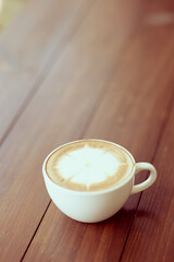 hot coffee in white cup on brown background