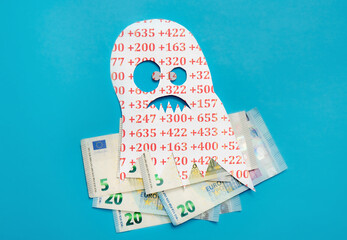 Conceptual image of Euribor as in scary monster floating above Euro money bank notes on blue studio...