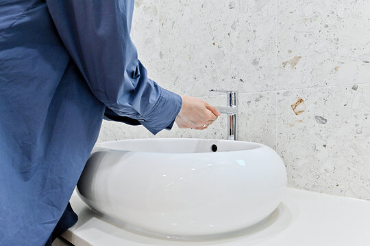 Back View Of A Woman Washing Her Hands In The Sink