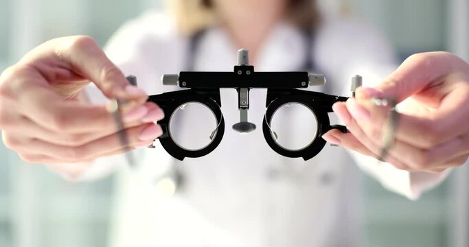 Hands of doctor of medicine give glasses for selection of glasses to patient