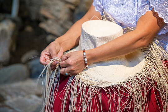 Ecuadorian indigenous chola woman weaving Panama hat from Toquilla palm leaf fiber, Cuenca, Ecuador.